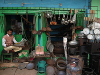 A vendor waits for his customers in his aluminum and iron utensils shop in Kolkata, India, on December 4, 2024. (