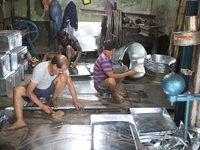 Workers mold aluminum plates with a hammer to make utensils at an aluminum utensils manufacturing unit in Kolkata, India, on December 4, 202...