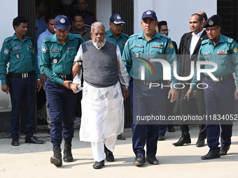 Police personnel escort detainee Amir Hossain Amu, former Minister and one of the top leaders of the Bangladesh Awami League party, to the I...