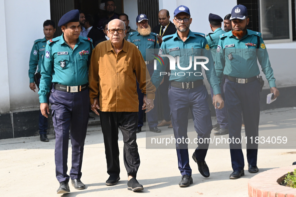 Police personnel escort detainee Advocate Qamrul Islam, former Minister and leader of the Bangladesh Awami League party, to the Internationa...