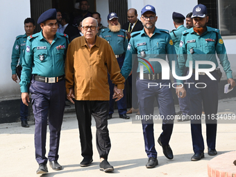 Police personnel escort detainee Advocate Qamrul Islam, former Minister and leader of the Bangladesh Awami League party, to the Internationa...