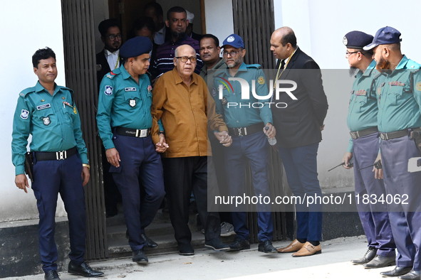 Police personnel escort detainee Advocate Qamrul Islam, former Minister and leader of the Bangladesh Awami League party, to the Internationa...