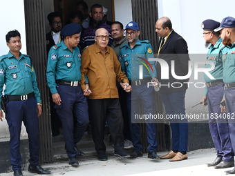 Police personnel escort detainee Advocate Qamrul Islam, former Minister and leader of the Bangladesh Awami League party, to the Internationa...