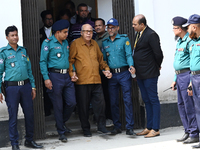 Police personnel escort detainee Advocate Qamrul Islam, former Minister and leader of the Bangladesh Awami League party, to the Internationa...