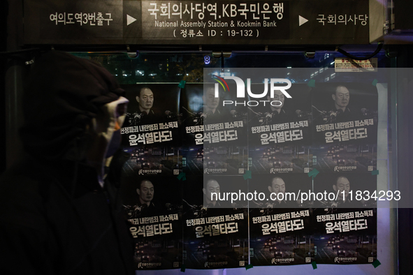 Posters featuring the face of President Yoon Suk-yeol superimposed onto the image of former military dictator Chun Doo-hwan are displayed at...