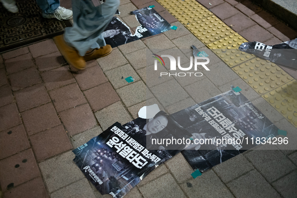 Posters featuring the face of President Yoon Suk-yeol superimposed onto the image of former military dictator Chun Doo-hwan lie scattered on...