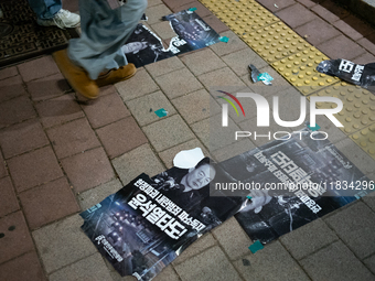 Posters featuring the face of President Yoon Suk-yeol superimposed onto the image of former military dictator Chun Doo-hwan lie scattered on...