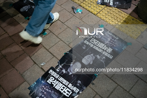 Posters featuring the face of President Yoon Suk-yeol superimposed onto the image of former military dictator Chun Doo-hwan lie scattered on...