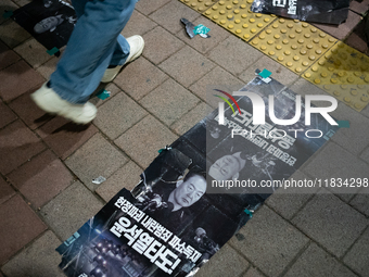 Posters featuring the face of President Yoon Suk-yeol superimposed onto the image of former military dictator Chun Doo-hwan lie scattered on...