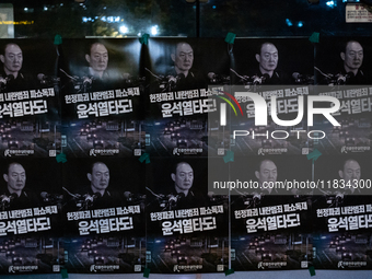 Posters featuring the face of President Yoon Suk-yeol superimposed onto the image of former military dictator Chun Doo-hwan are displayed at...