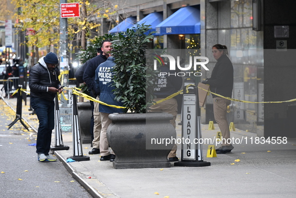 NYPD police mark evidence found at the scene with evidence markers as CEO of UnitedHealthcare Brian Thompson, 50, is shot and killed as he e...