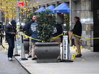 NYPD police mark evidence found at the scene with evidence markers as CEO of UnitedHealthcare Brian Thompson, 50, is shot and killed as he e...