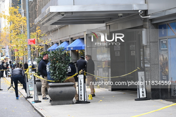 NYPD police mark evidence found at the scene with evidence markers as CEO of UnitedHealthcare Brian Thompson, 50, is shot and killed as he e...