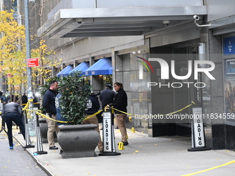 NYPD police mark evidence found at the scene with evidence markers as CEO of UnitedHealthcare Brian Thompson, 50, is shot and killed as he e...