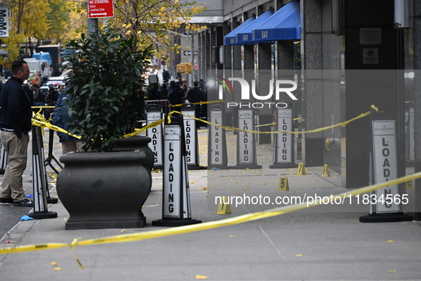 NYPD police mark evidence found at the scene with evidence markers as CEO of UnitedHealthcare Brian Thompson, 50, is shot and killed as he e...