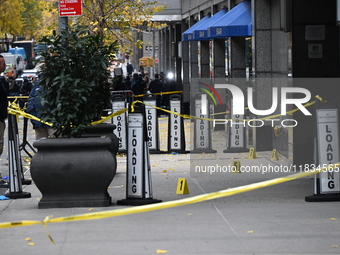 NYPD police mark evidence found at the scene with evidence markers as CEO of UnitedHealthcare Brian Thompson, 50, is shot and killed as he e...