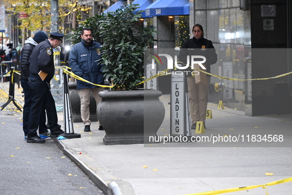 NYPD police mark evidence found at the scene with evidence markers as CEO of UnitedHealthcare Brian Thompson, 50, is shot and killed as he e...