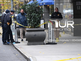 NYPD police mark evidence found at the scene with evidence markers as CEO of UnitedHealthcare Brian Thompson, 50, is shot and killed as he e...