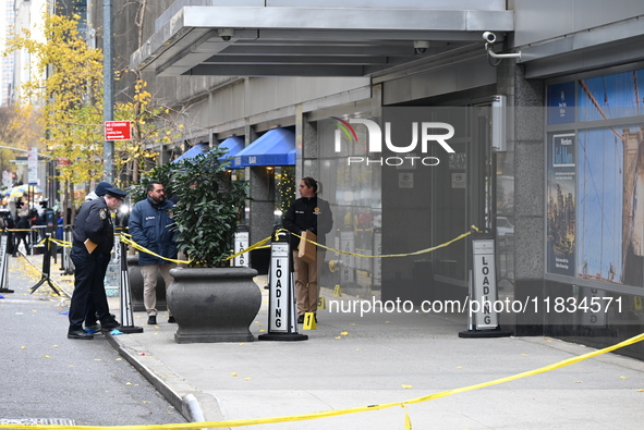 NYPD police mark evidence found at the scene with evidence markers as CEO of UnitedHealthcare Brian Thompson, 50, is shot and killed as he e...