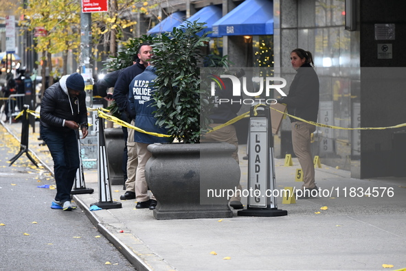 NYPD police mark evidence found at the scene with evidence markers as CEO of UnitedHealthcare Brian Thompson, 50, is shot and killed as he e...