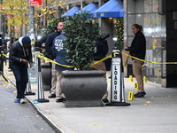 NYPD police mark evidence found at the scene with evidence markers as CEO of UnitedHealthcare Brian Thompson, 50, is shot and killed as he e...