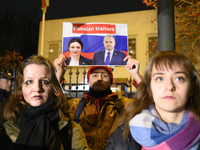 A demonstrator holds a sign depicting members of the Georgian Dream party on a Russian flag as the background during a rally outside the emb...