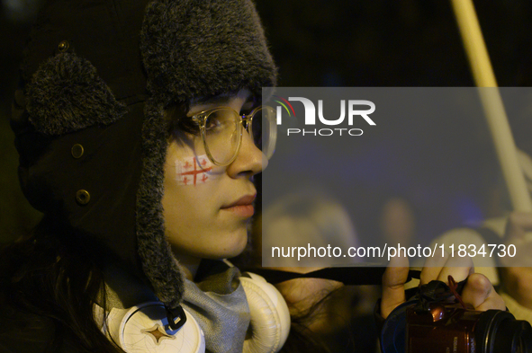 A demonstrator has a flag of Georgia painted on her face as she takes part in a rally outside the embassy of Georgia in Warsaw, Poland, on D...