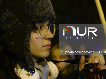 A demonstrator has a flag of Georgia painted on her face as she takes part in a rally outside the embassy of Georgia in Warsaw, Poland, on D...