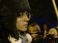 A demonstrator has a flag of Georgia painted on her face as she takes part in a rally outside the embassy of Georgia in Warsaw, Poland, on D...