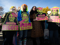 People with signs accusing Supreme Court justices of misconduct take part in a demonstration outside the Court as it hears a case on gender-...