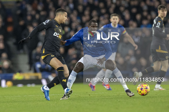 Joao Gomes #8 of Wolverhampton Wanderers F.C. is tackled by Abdoulaye Doucoure #16 of Everton F.C. during the Premier League match between E...