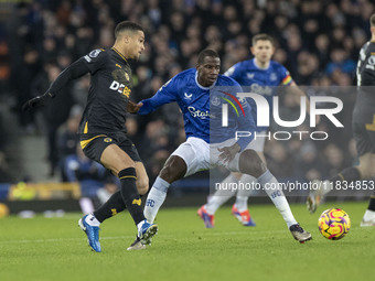 Joao Gomes #8 of Wolverhampton Wanderers F.C. is tackled by Abdoulaye Doucoure #16 of Everton F.C. during the Premier League match between E...