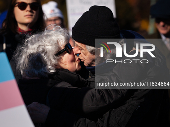 Two people meet with a kiss at a demonstration in support of gender-affirming care for transgender children, while the Supreme Court hears a...