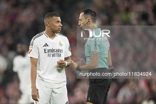 Kylian Mbappe centre-forward of Real Madrid and France talks with referee Jose Maria Sanchez Martinez during the La Liga match between Athle...