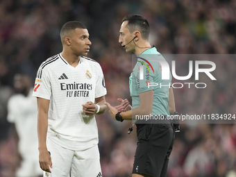 Kylian Mbappe centre-forward of Real Madrid and France talks with referee Jose Maria Sanchez Martinez during the La Liga match between Athle...