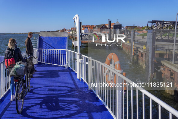 A young lady with her bicycle waits to disembark the ferry after it docks in Nordby, Fano Island, Denmark, on April 29, 2024. 