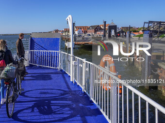 A young lady with her bicycle waits to disembark the ferry after it docks in Nordby, Fano Island, Denmark, on April 29, 2024. (