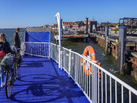 A young lady with her bicycle waits to disembark the ferry after it docks in Nordby, Fano Island, Denmark, on April 29, 2024. (