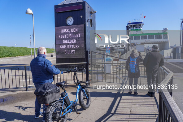 People wait for the all-electric ferry that runs between Island and Esbjerg, belonging to the Fanolinjen, in Nordby, Fano Island, Denmark, o...