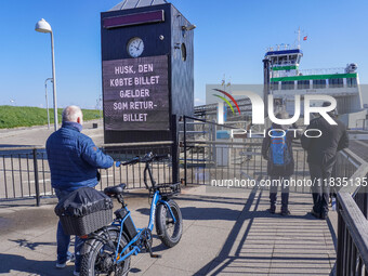 People wait for the all-electric ferry that runs between Island and Esbjerg, belonging to the Fanolinjen, in Nordby, Fano Island, Denmark, o...