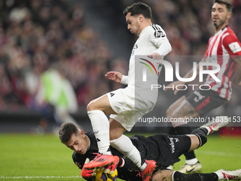 Brahim Diaz attacking midfield of Real Madrid and Spain and Julen Agirrezabala goalkeeper of Athletic Club and Spain compete for the ball du...