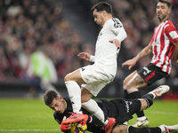 Brahim Diaz attacking midfield of Real Madrid and Spain and Julen Agirrezabala goalkeeper of Athletic Club and Spain compete for the ball du...