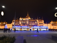 A tram decorated with Christmas lights passes in front of the Hungarian Parliament in Budapest, Hungary, on December 4, 2024. (