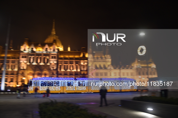 A tram decorated with Christmas lights passes in front of the Hungarian Parliament in Budapest, Hungary, on December 3, 2024.