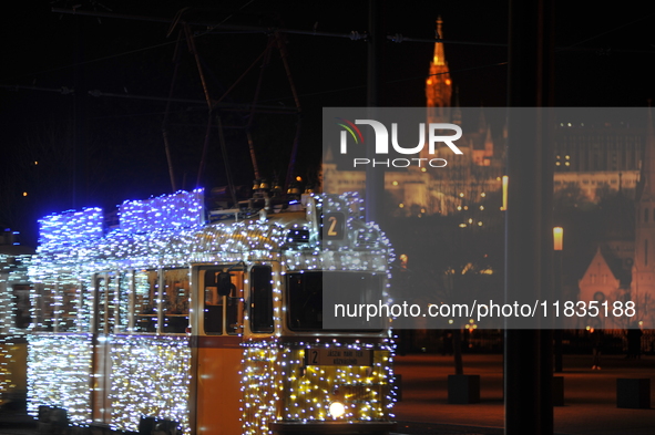 A tram decorated with Christmas lights passes in front of the Fisherman's Bastion in Budapest, Hungary, on December 4, 2024. 