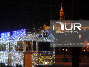 A tram decorated with Christmas lights passes in front of the Fisherman's Bastion in Budapest, Hungary, on December 4, 2024. (