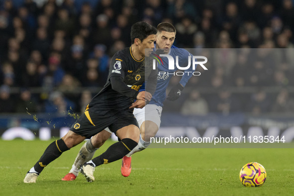 Hwang Hee-chan #11 of Wolverhampton Wanderers F.C. is tackled by Vitaliy Mykolenko #19 of Everton F.C. during the Premier League match betwe...