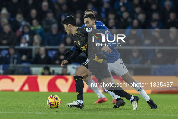 Hwang Hee-chan #11 of Wolverhampton Wanderers F.C. is challenged by Dwight McNeil #7 of Everton F.C. during the Premier League match between...