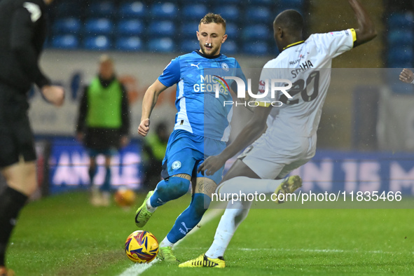 Sam Curtis of Peterborough United challenges Jason Sraha of Burton Albion during the Sky Bet League 1 match between Peterborough United and...