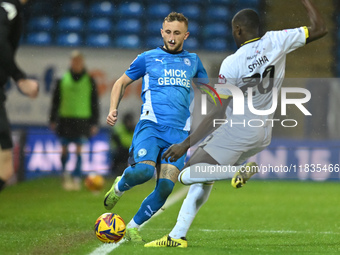 Sam Curtis of Peterborough United challenges Jason Sraha of Burton Albion during the Sky Bet League 1 match between Peterborough United and...